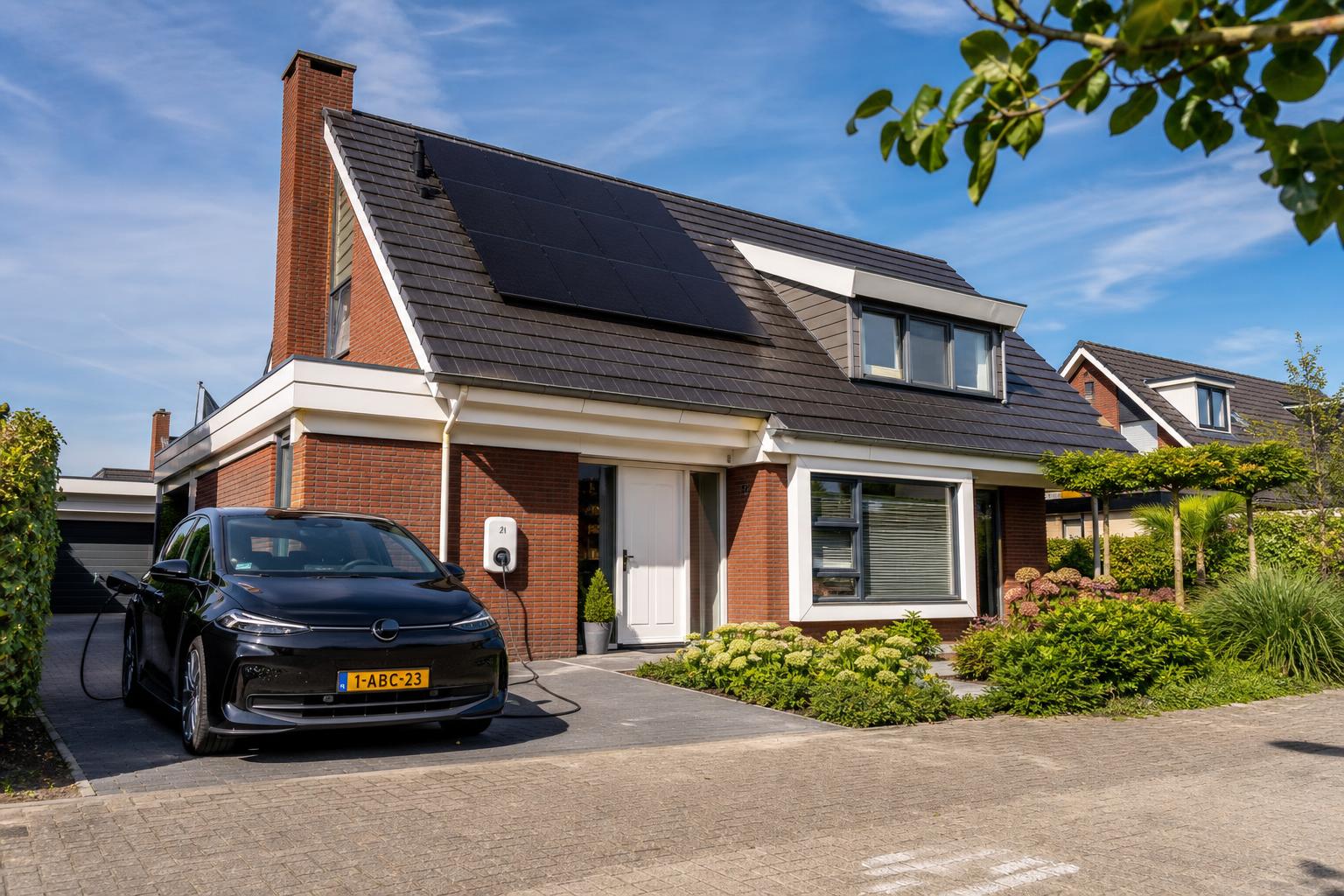 Nederlandse woning met zonnepanelen en elektrische auto met Nederlands kenteken aangesloten op een laadpaal